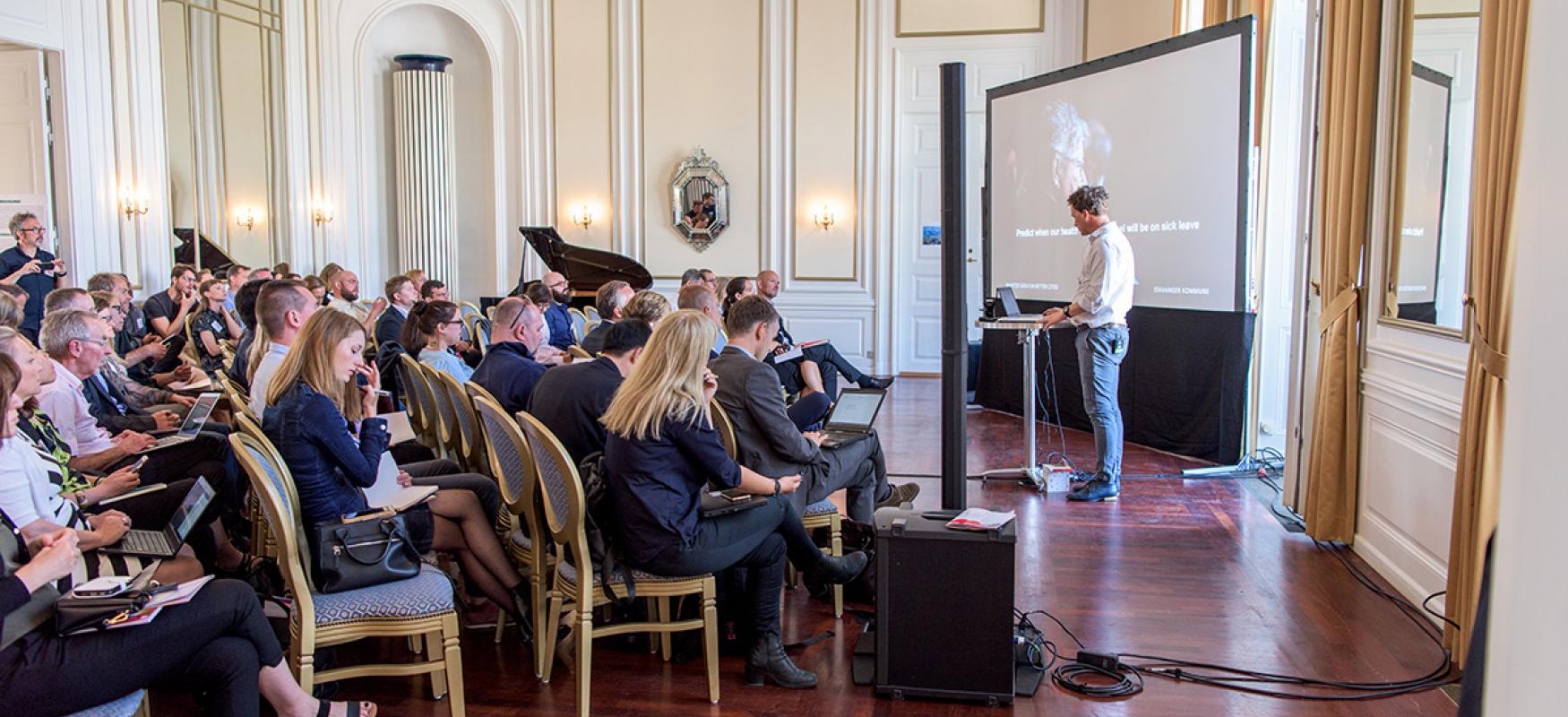 Man speaking in front of a crowd at the Sustainable Urban Solutions 2018 conference.