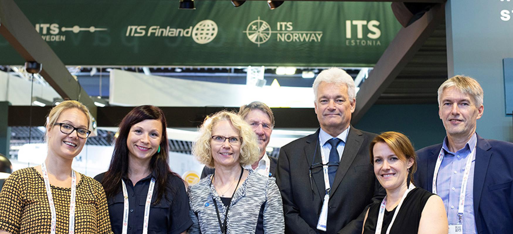 Group of people standing in front of a conference stand