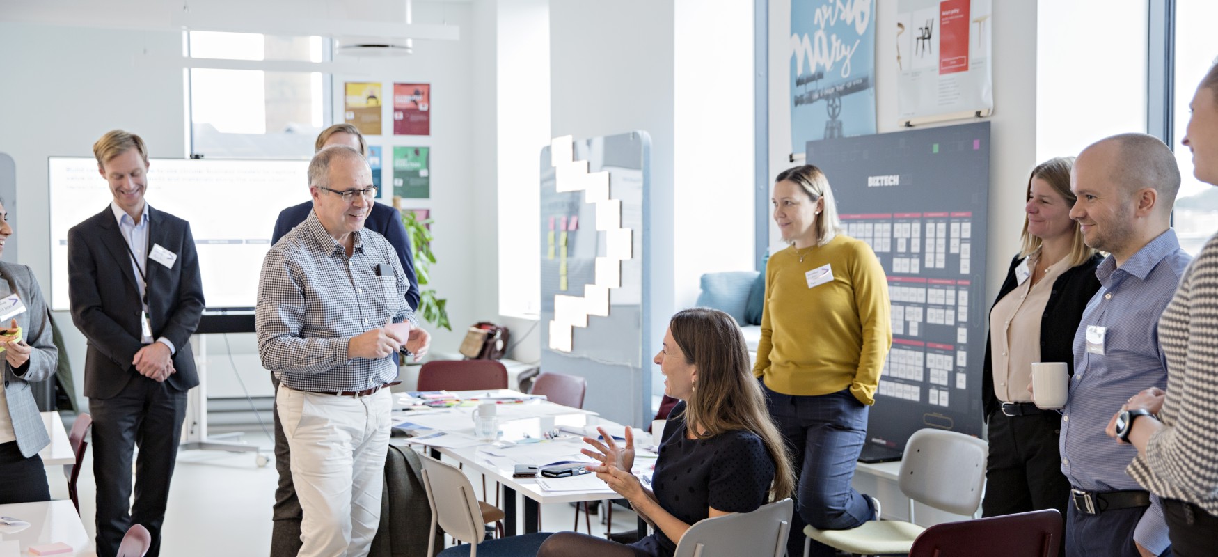 Workshop in Copenhagen, group of attendees sitting and standing while disucssing business cases