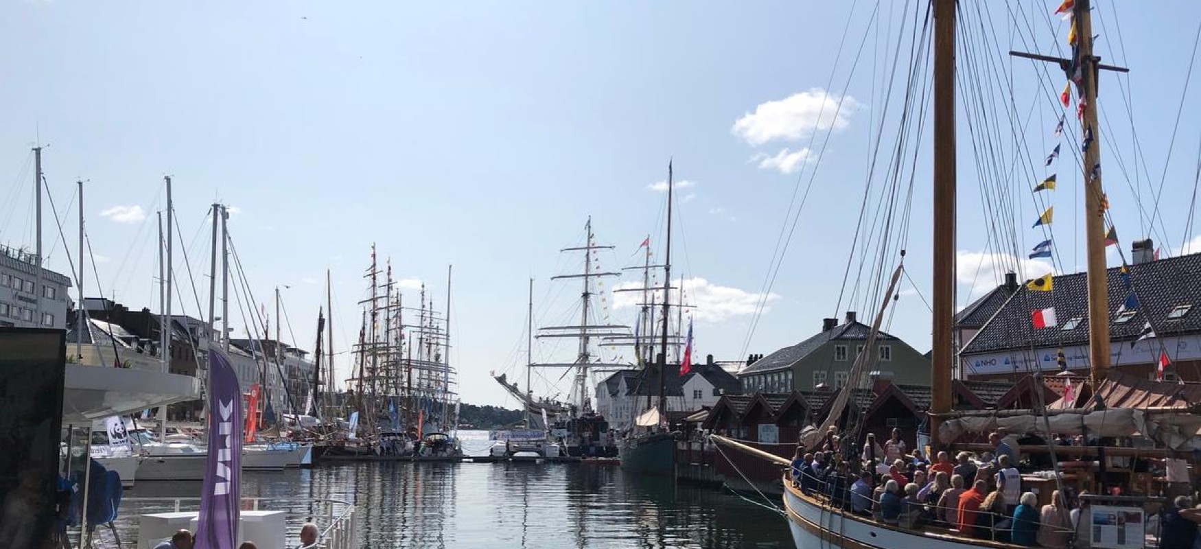Arendal during Arendalsuka. View of the harbour, sunshine and a boat full of people.