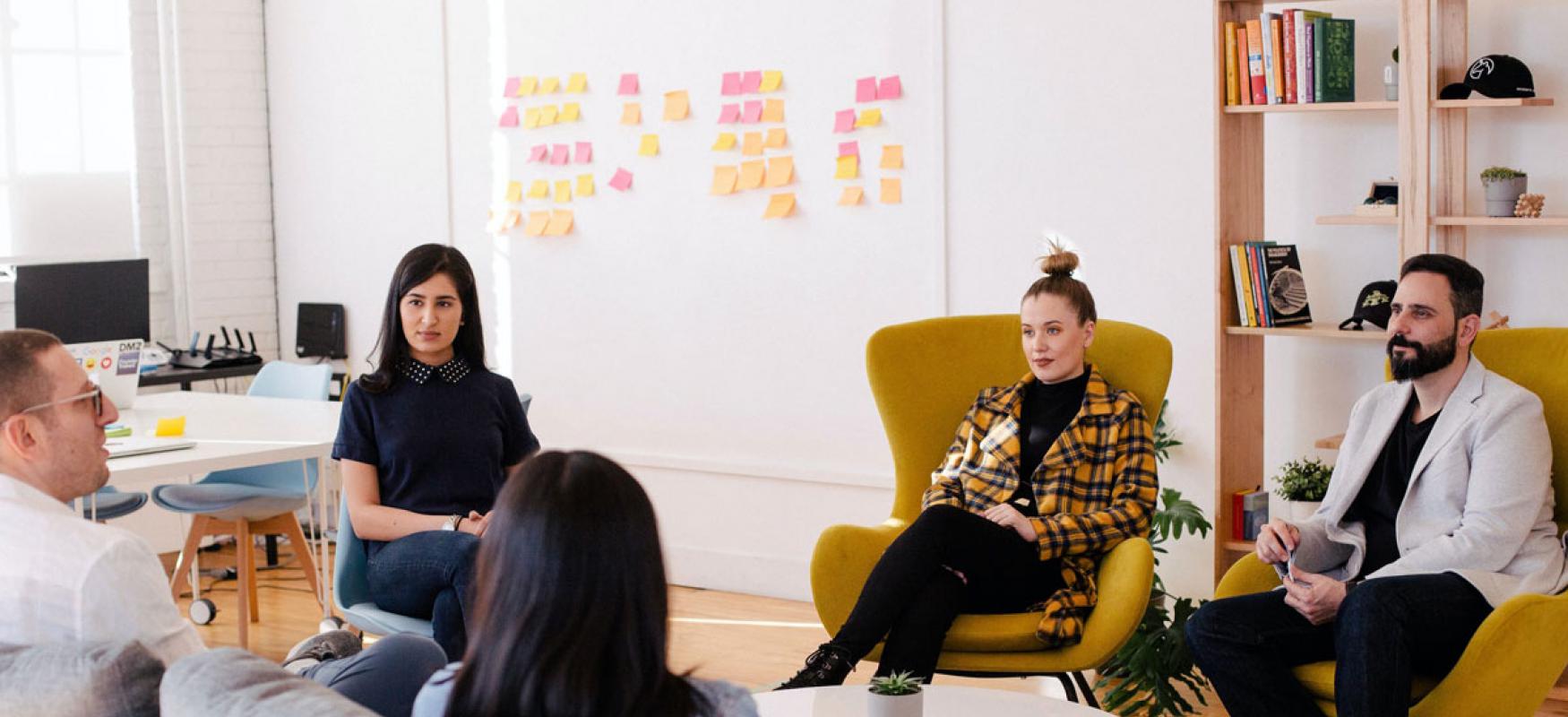 Five people having a business meeting in a modern office.