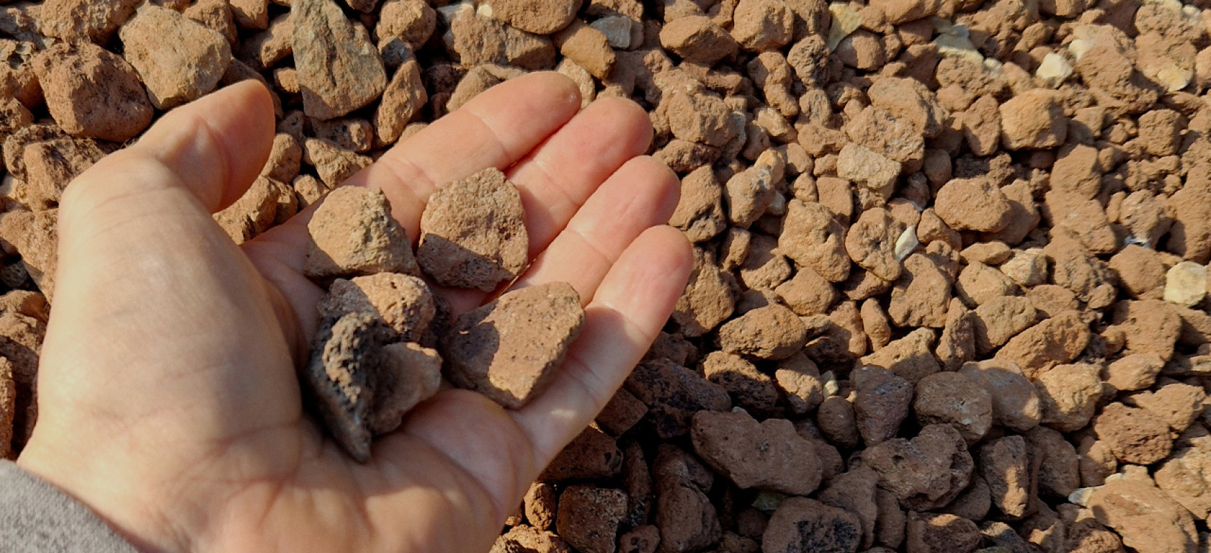 Hand holding gravel and stones