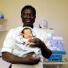 Nurse holding a newborn baby at a hospital.