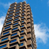 Picture of a high rise building seen from the street and stretching towards the sky