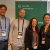 Four persons posing for a photo infront of a Nordic Innovation roll up